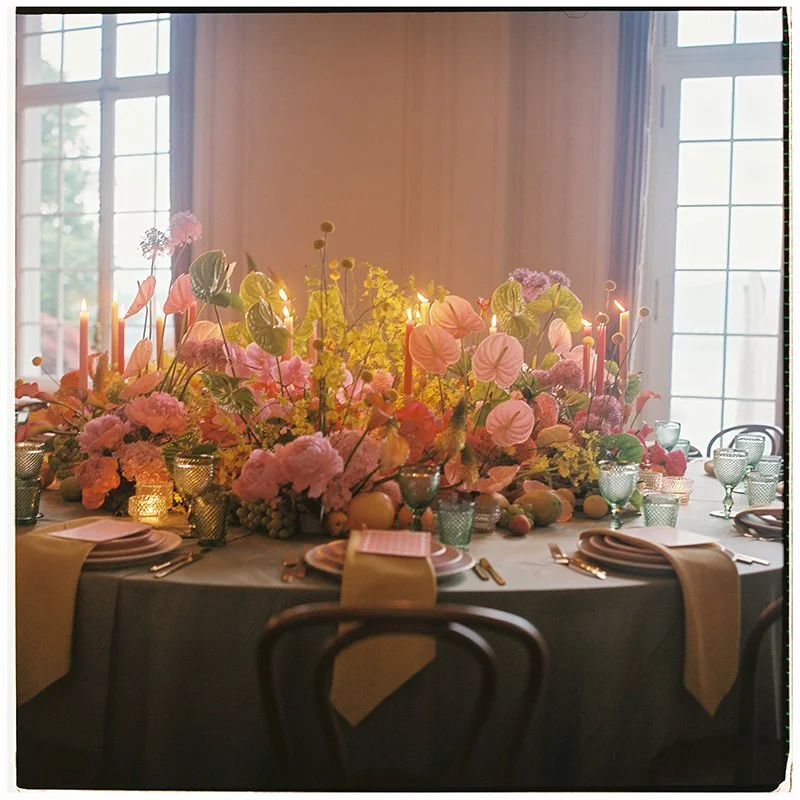 Ein Tisch ist eingedeckt und dekoriert mit vielen bunten Blumen.