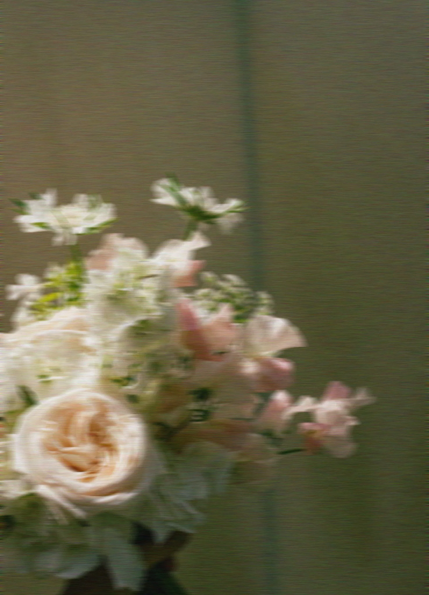 Ein Blumenbouquet wird vor einem neutralen Hintergrund gehalten und ist in Bewegung.