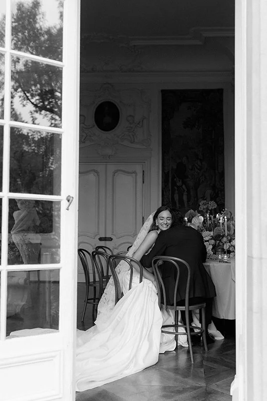 Eine Frau sitzt lachend neben ihrem Mann in einem Raum.