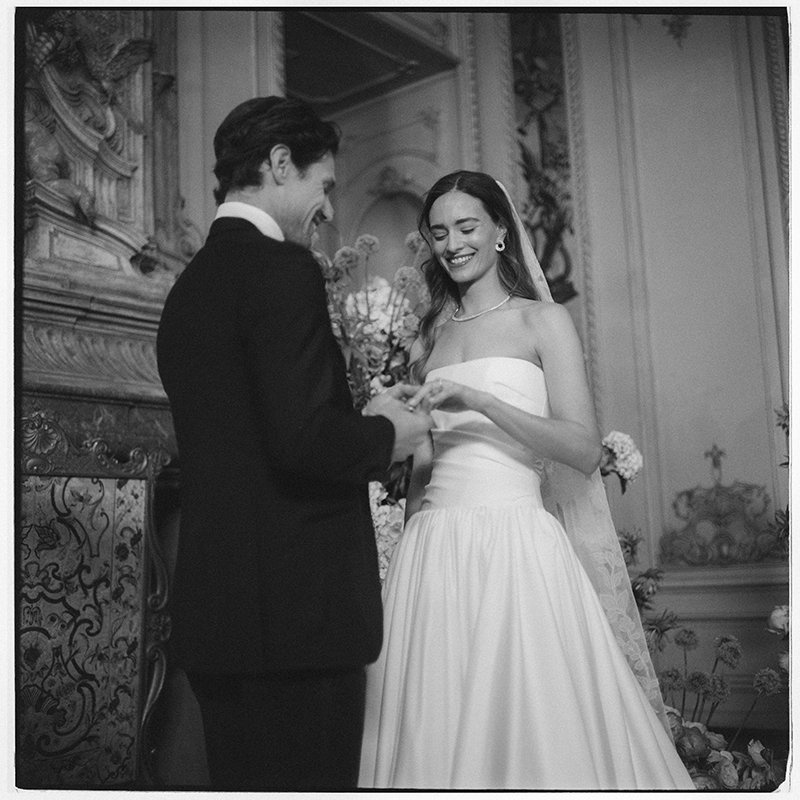 Ein Brautpaar tauscht lachend die Ringe aus.