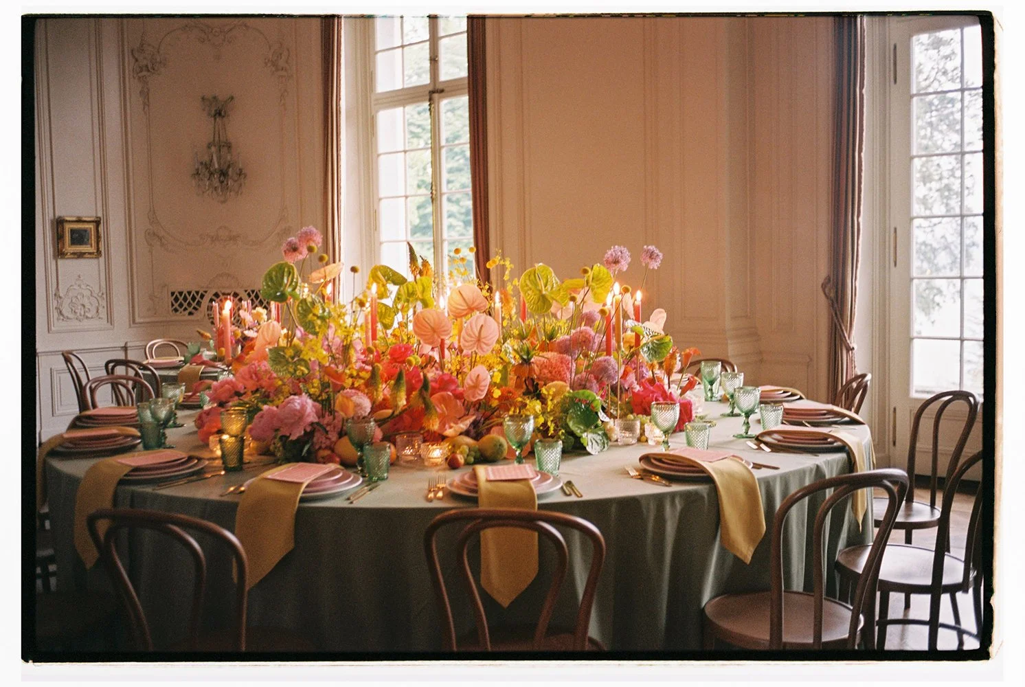 Ein eingedeckter Tisch der gefüllt ist mit vielen bunten Blumen.