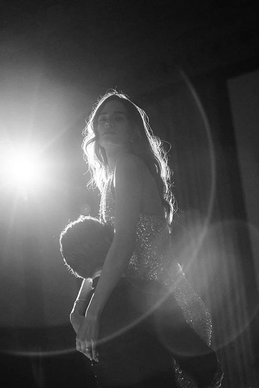 Ein Mann hält eine Frau in einem Glitzerkleid in die Höhe.