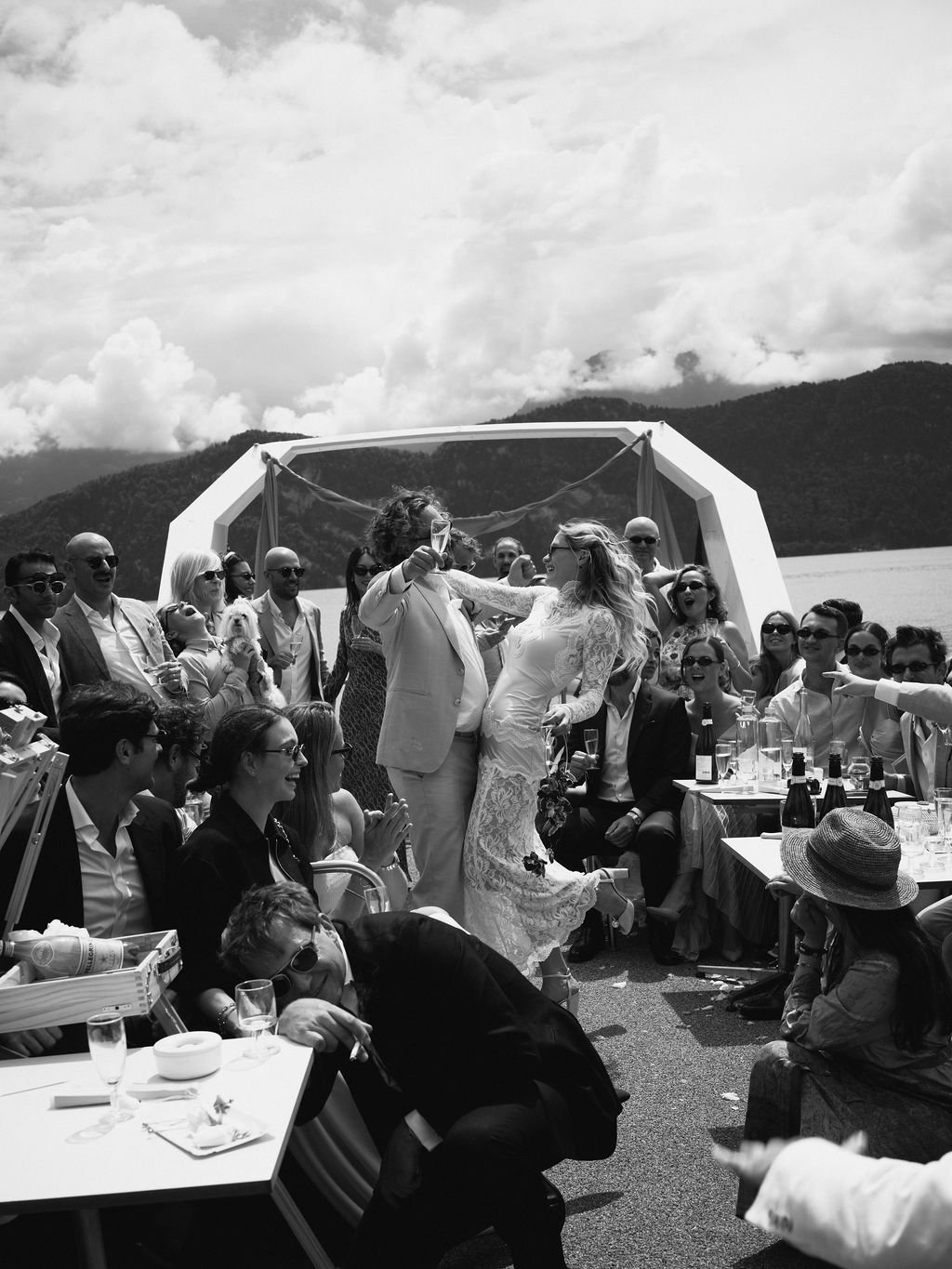 Ein Brautpaar tanz umgeben von Leuten auf einem Schiff.