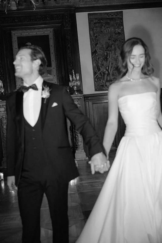 Ein Brautpaar läuft Hand in Hand und lachend zur Kamera.