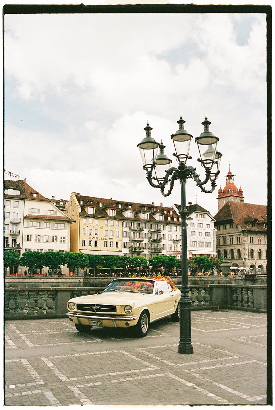 Ein hellgelber Mustang steht neben einer alten Strassenlaterne in der Altstadt von Luzern.