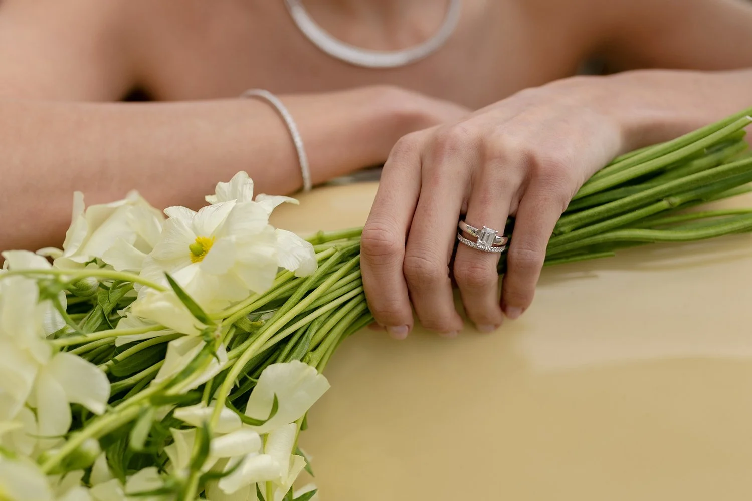 Eine Hand mit Silberringen die ein Blumenstrauss hält.
