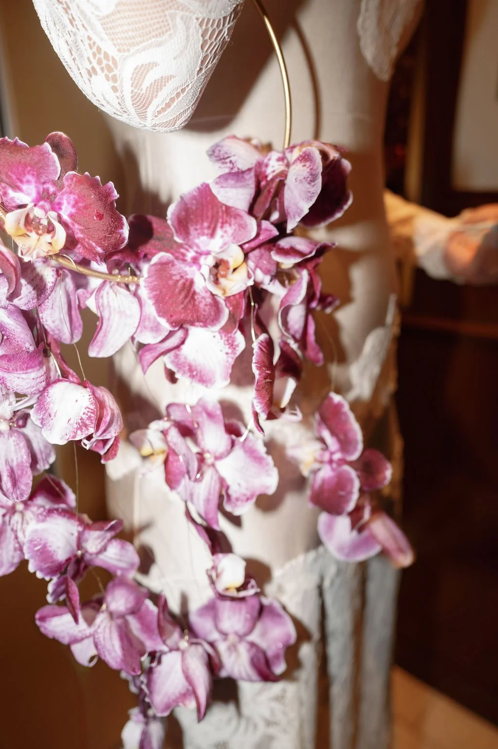 Eine Frau hält einen Ring mit violetten Phalenopsis.