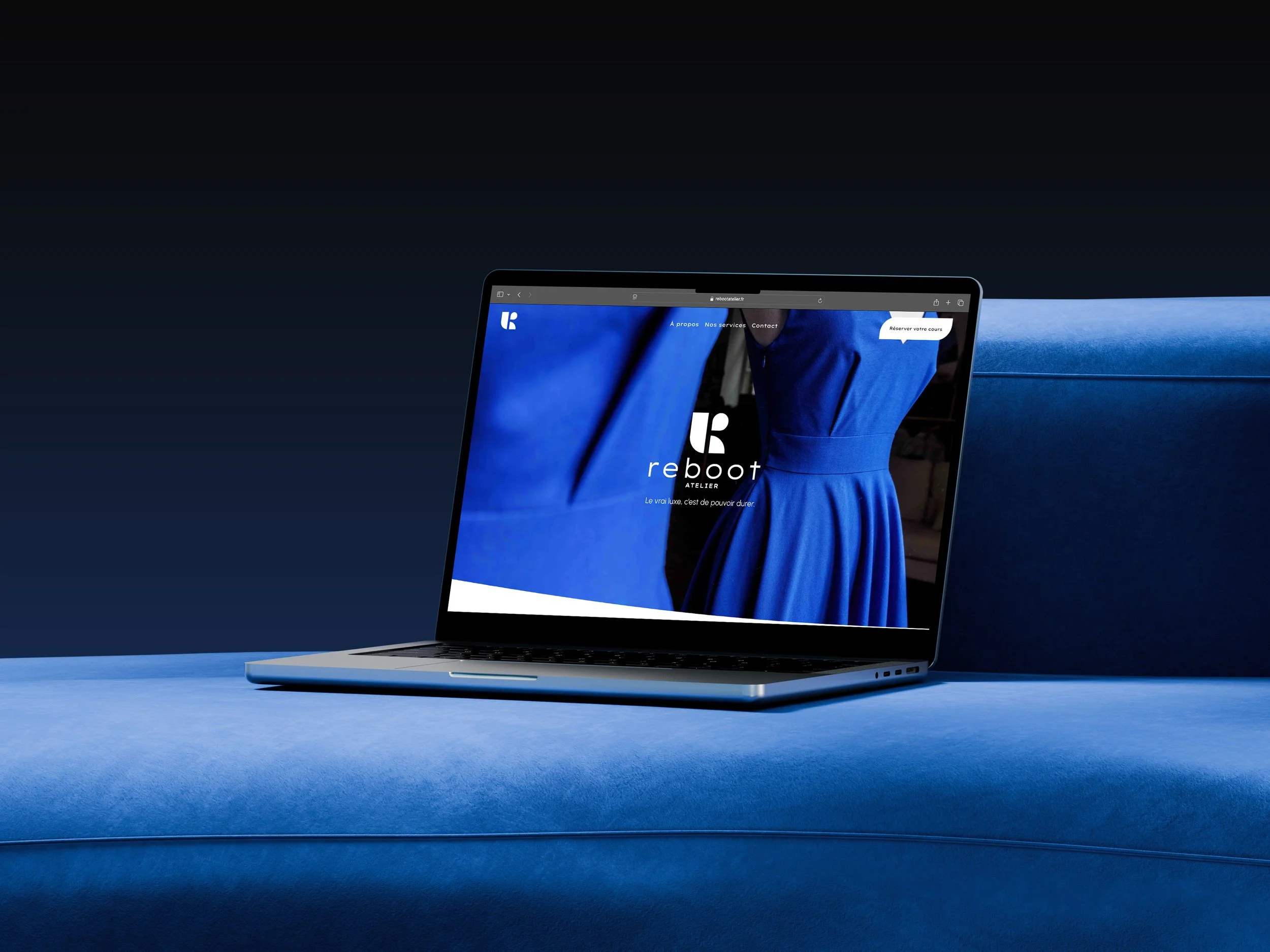 Un ordinateur portable argenté sur une surface bleue sombre affichant un site web avec un fond bleu Royal et une femme en costume bleu