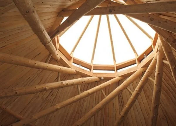 Interior view of a wooden ceiling with radial beam structure and skylight