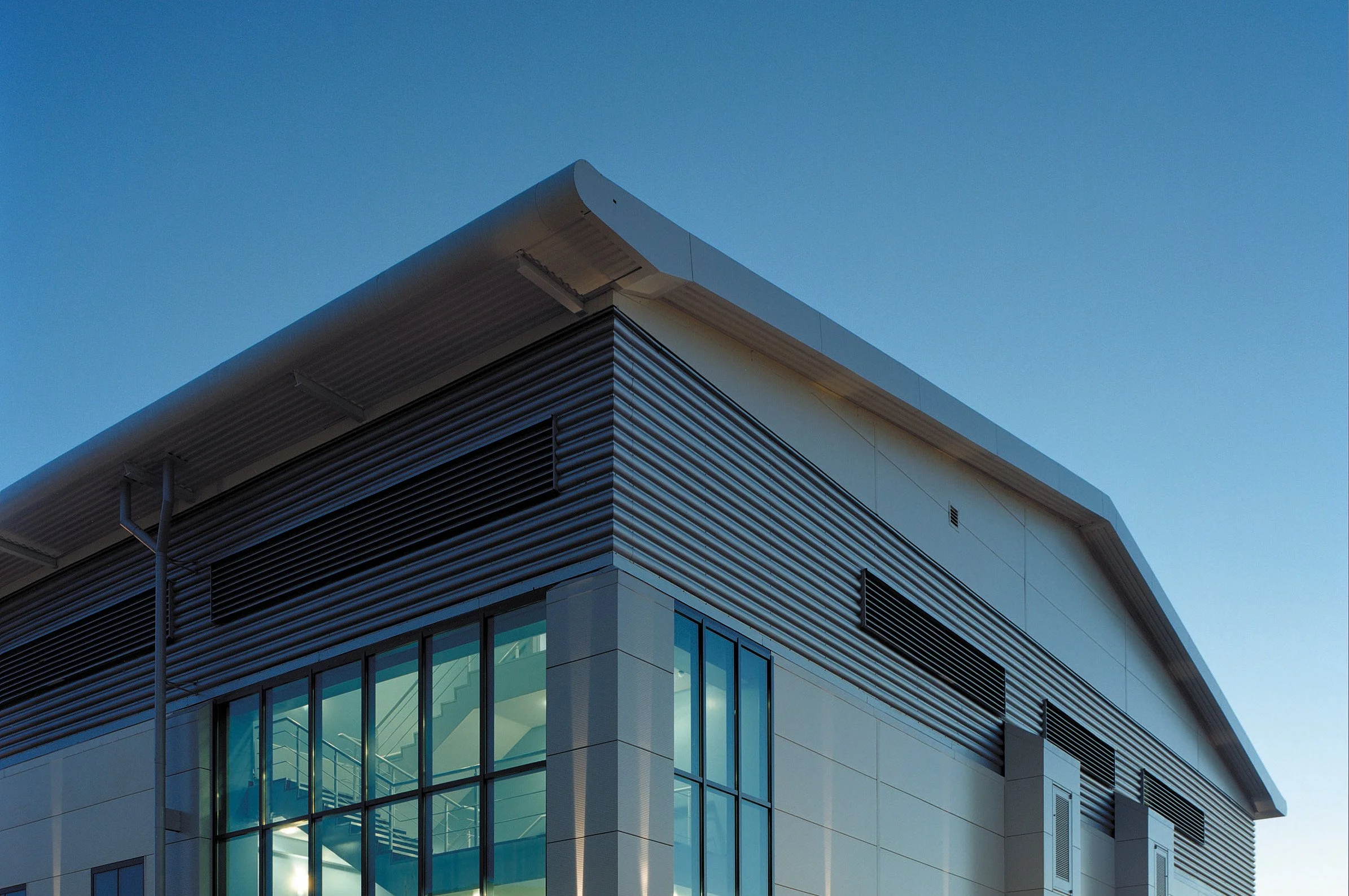 Modern building with corrugated metal siding and large windows.