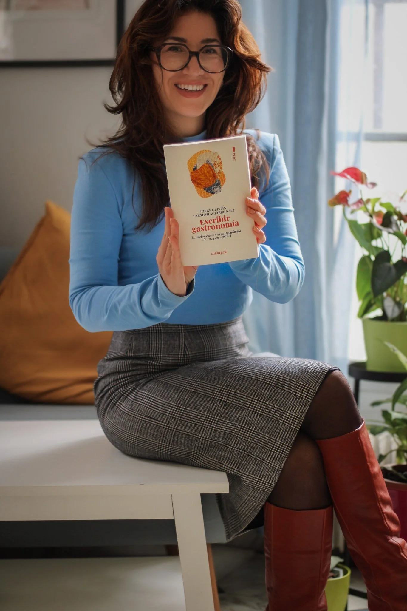 Vinka sits with a copy of Escribir Gastronomia 2024