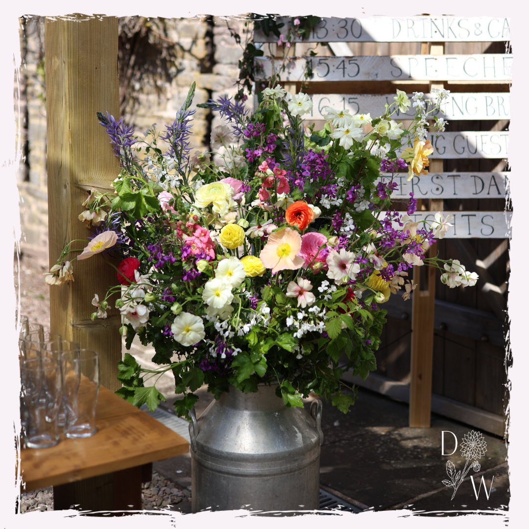 Seasonal Welsh spring wedding flowers milk churn arrangement