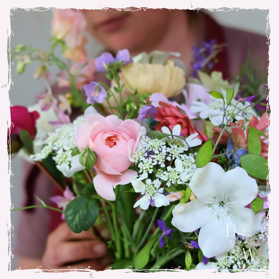 hands holding a spring bouquet mixed flowers