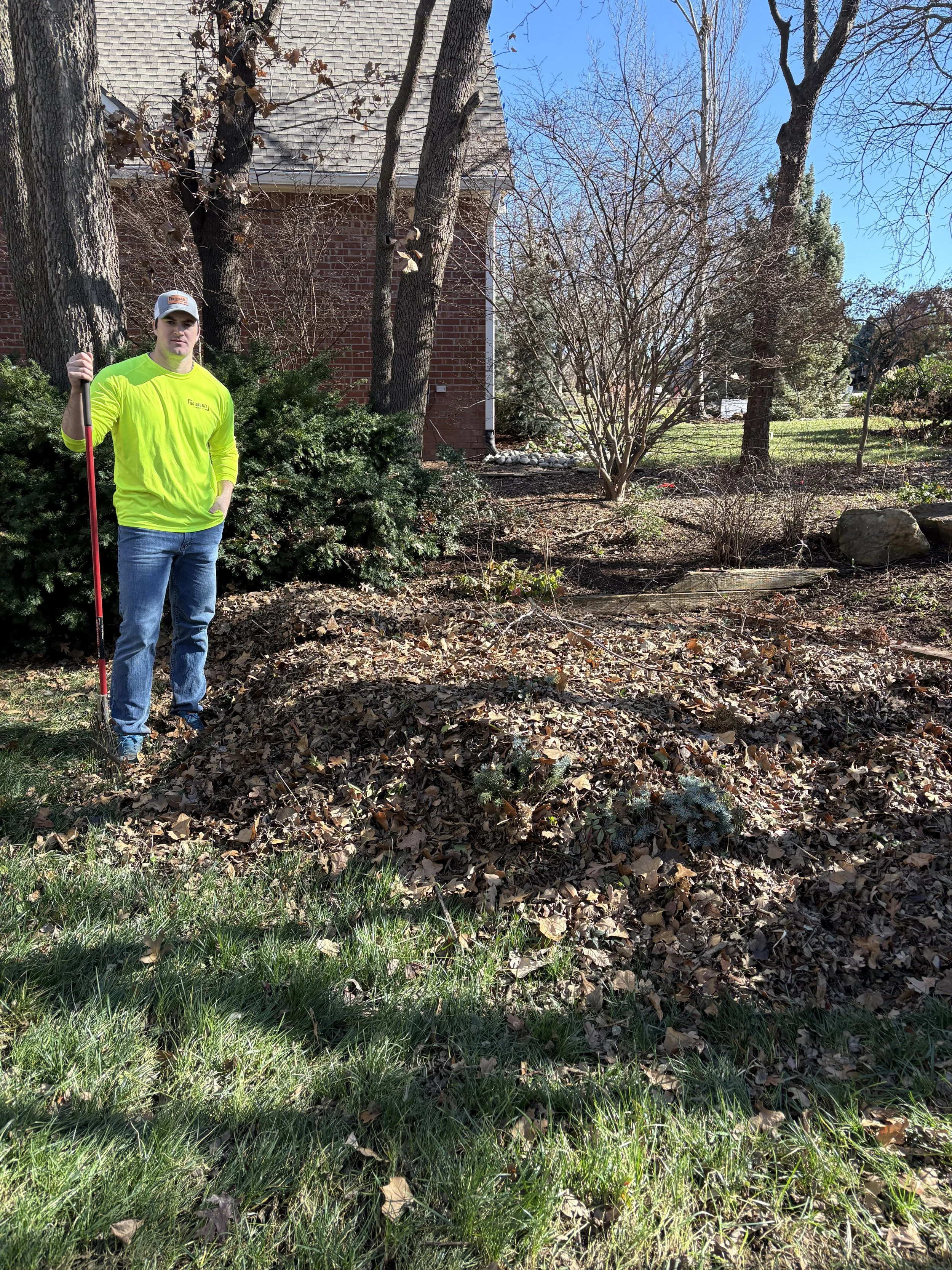 owner-standing-with-leaf-pile