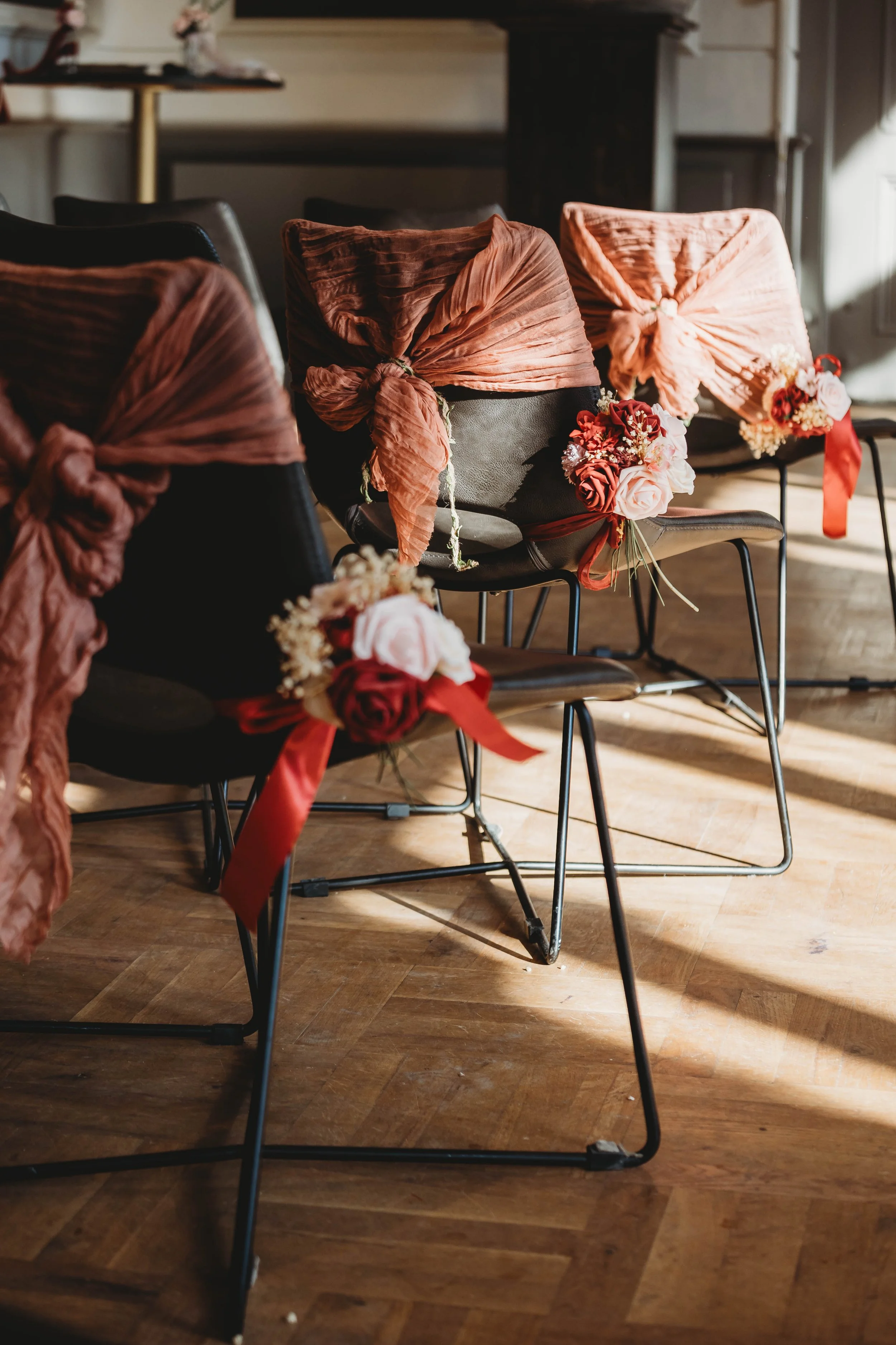 Stoelen met roze tinten en bloemen, versierd voor een evenement of bruiloft.