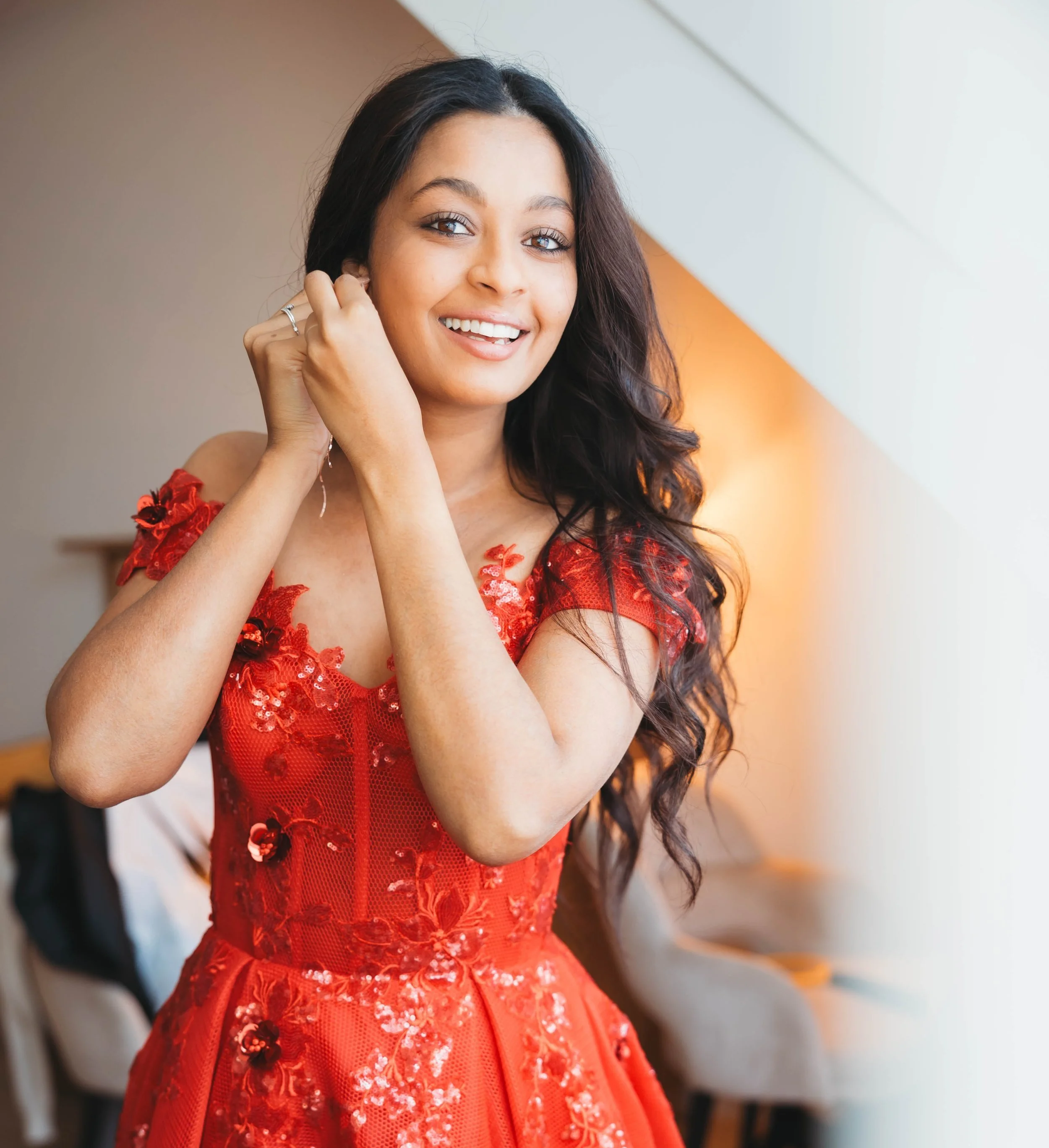 Vrouw in een rode jurk die glimlacht in een interieur