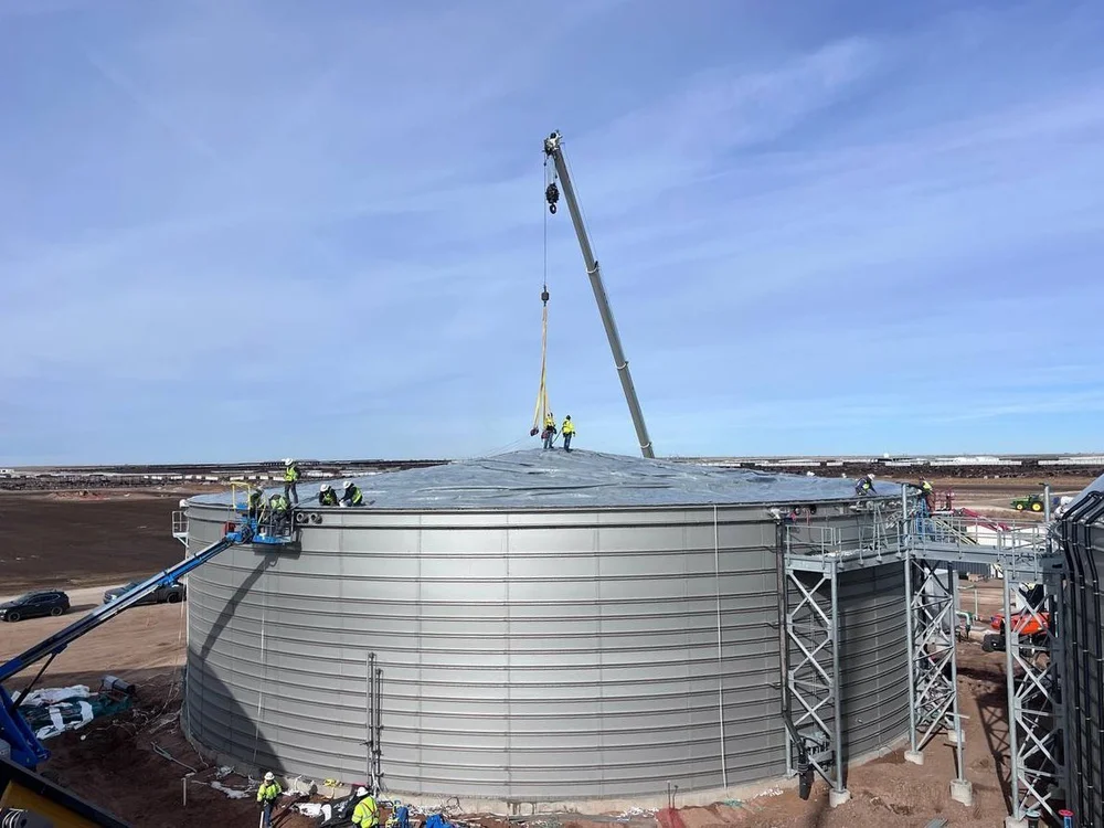 Bolted steel tank during erection with crane and lifts