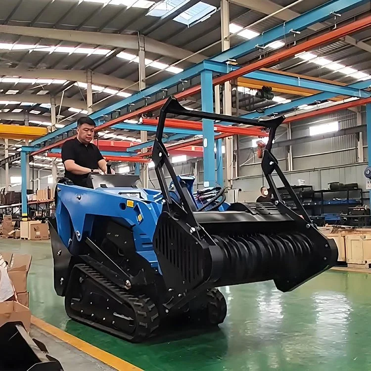 Operator driving a blue mini track loader inside a warehouse