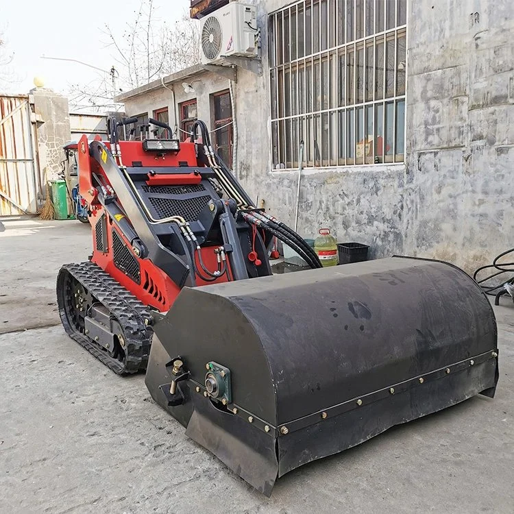 Red tracked skid steer loader with attachment in urban setting