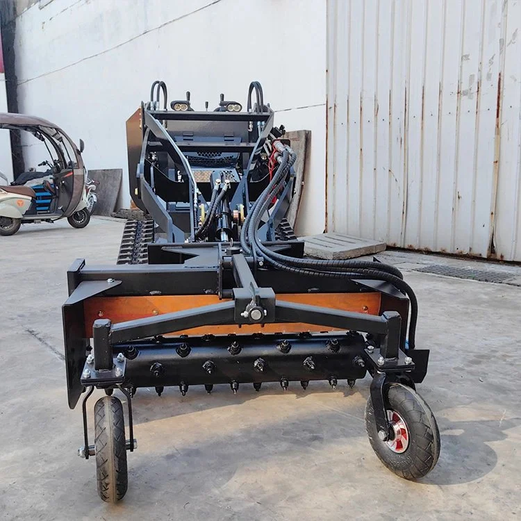 Front view of industrial machinery with wheels, hydraulic hoses, and a background of a concrete floor and building.