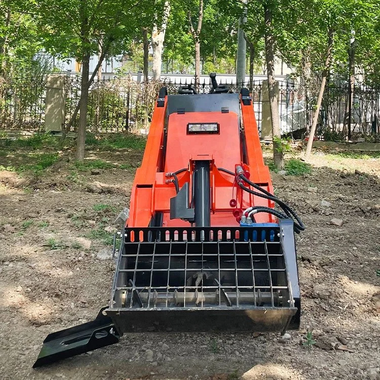 Red mini skid steer loader on dirt ground in forested area