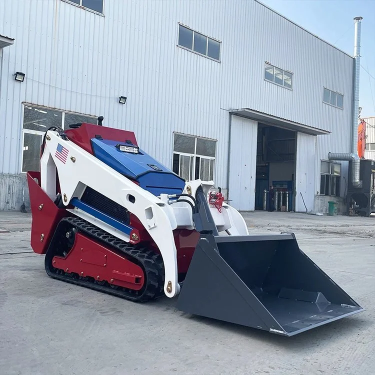 Mini skid steer loader with bucket attachment outside a warehouse.
