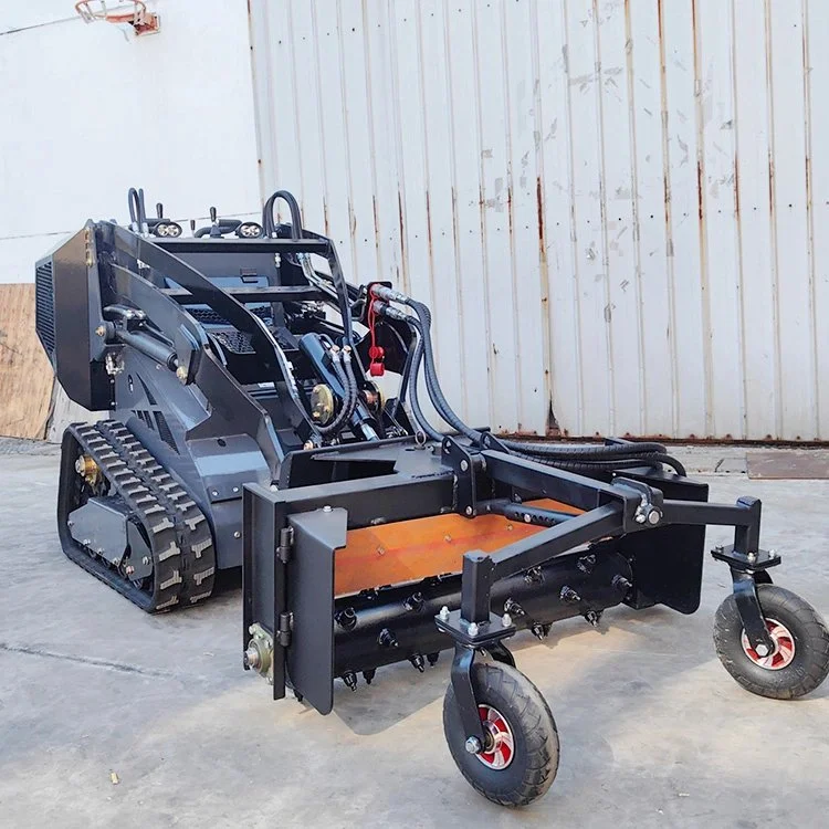 Compact tracked loader with industrial attachment on concrete surface