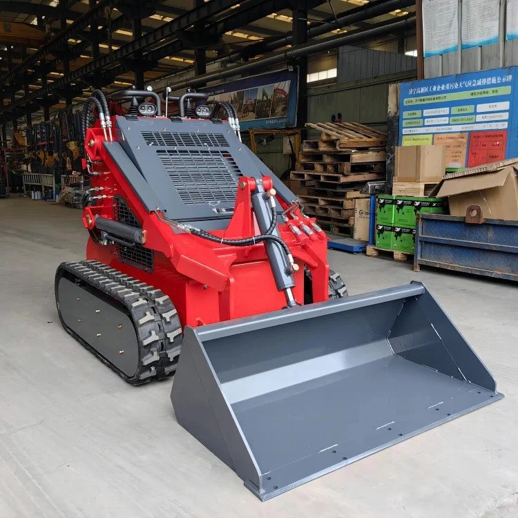 Red mini skid steer loader with bucket attachment indoors