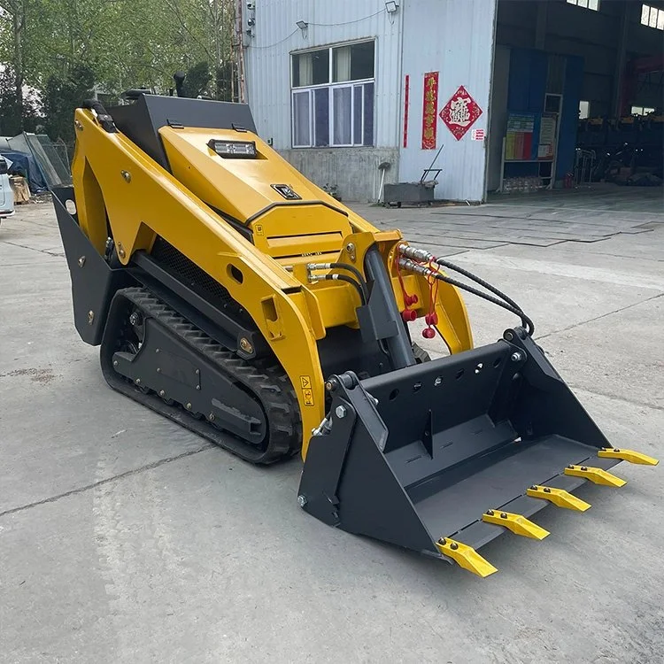 Yellow compact track loader with front bucket attachment on concrete surface.
