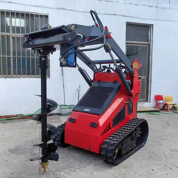 Red mini excavator with auger attachment in front of a building