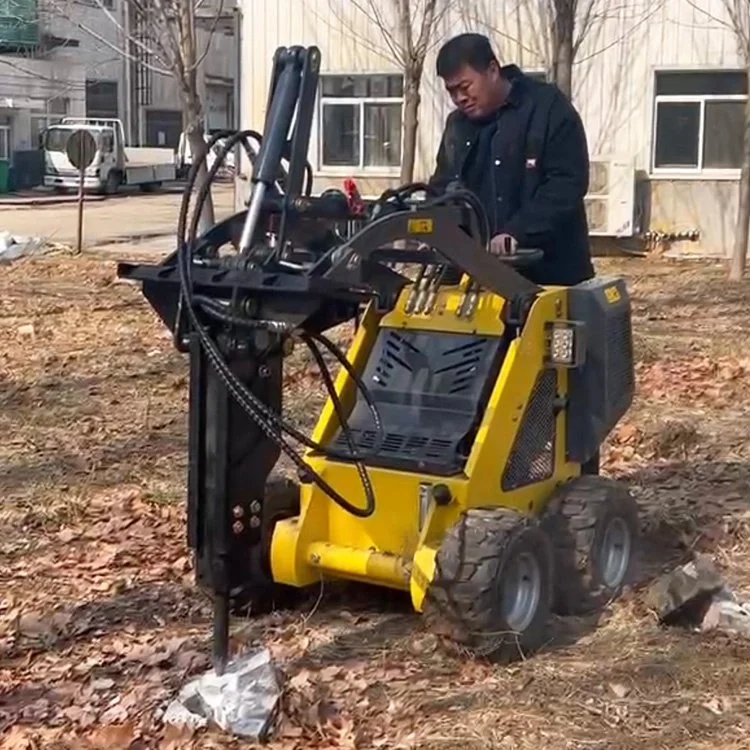 Person operating a yellow mini skid steer with an auger attachment on a dirt field