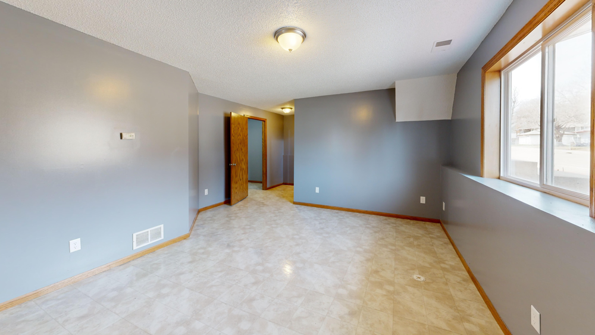 Bright empty room with gray walls showing how condition and presentation affect buyer perception.