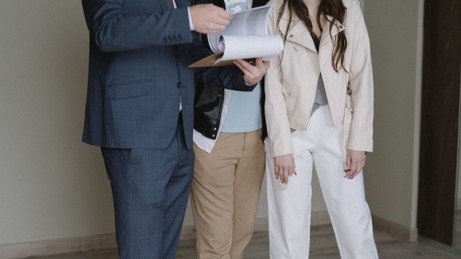 Buyer and real estate agent reviewing property documents before closing.