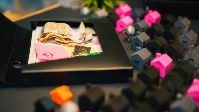 Miniature houses, keys, and cash representing Mansfield home value and investment analysis