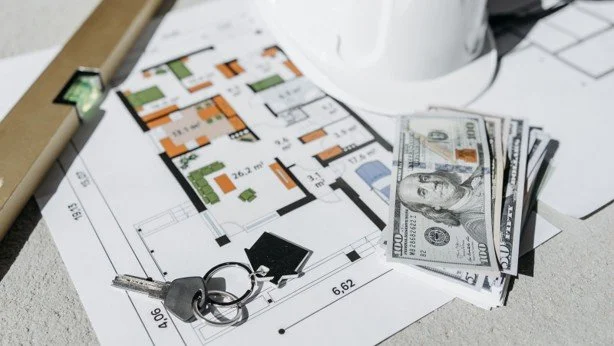 House keys, cash, and a floor plan representing down payment assistance and closing costs for DFW home buyers.