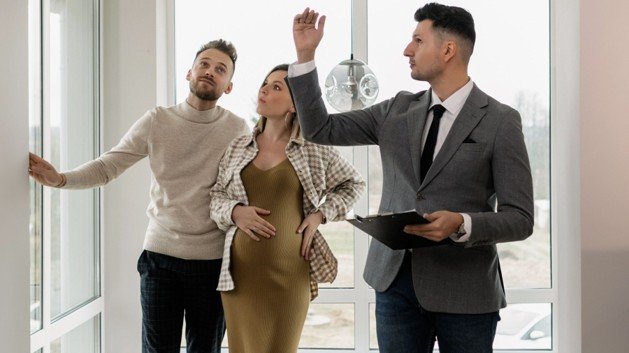 Real estate agent walking buyers through a home while discussing property details and value.