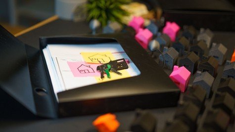 Home insurance and property documents with house keys and small home models on a desk.