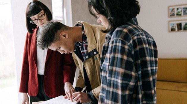 People reviewing and signing real estate paperwork during a contract negotiation