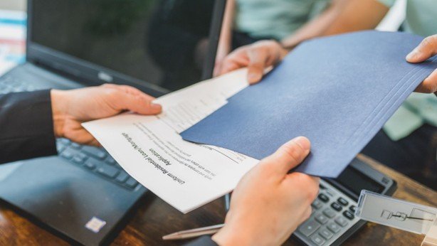 Real estate documents being reviewed for first-time home buyer assistance programs in Dallas-Fort Worth.