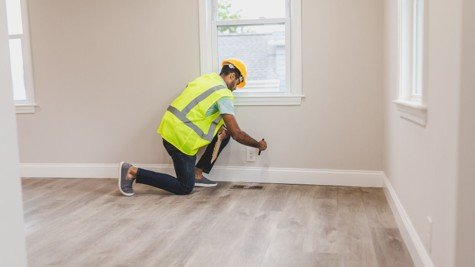 Home inspector checking an electrical outlet during a buyer inspection inside a Mansfield area home.
