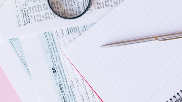 Tax documents with calculator, magnifying glass, and notebook representing an appraisal protest review.