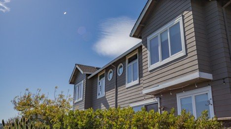Established suburban home exterior with mature landscaping and blue sky.