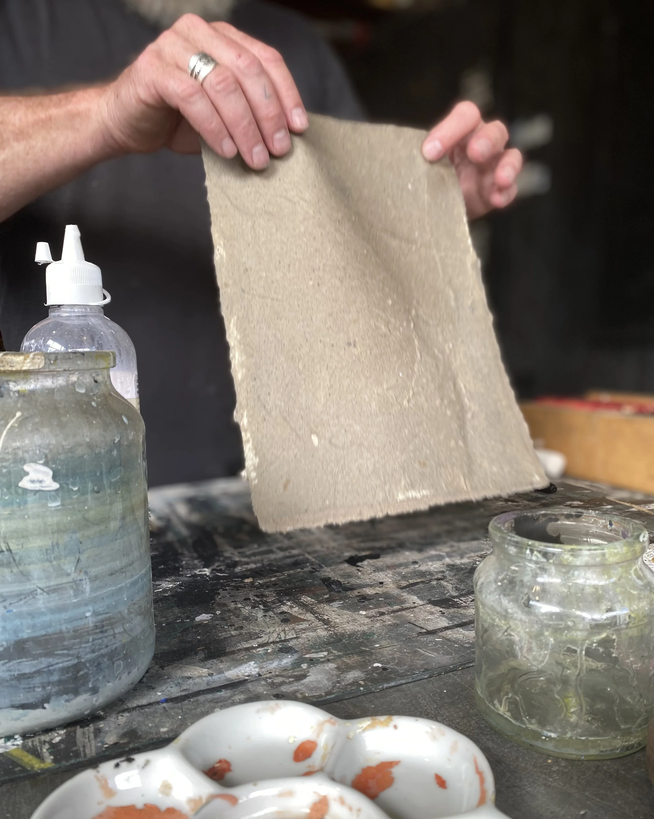 A group of 25 people are seated with their backs to image.  They are waiting for an architectural talk to start and they are looking at a projection of a building on the VA wall.