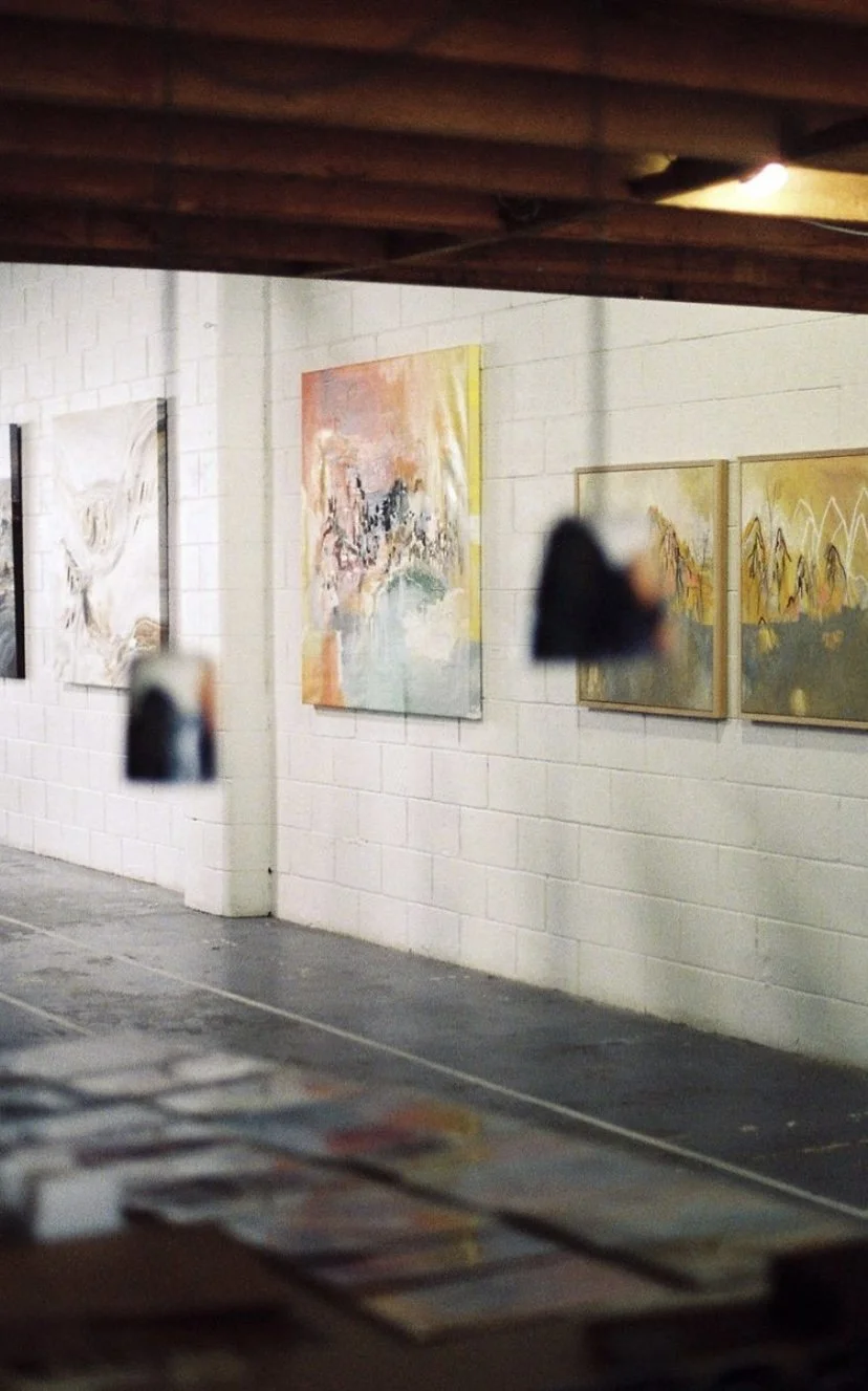 View of a painting show at Vacant Assembly.  Large canvases with pastel colors in the distance