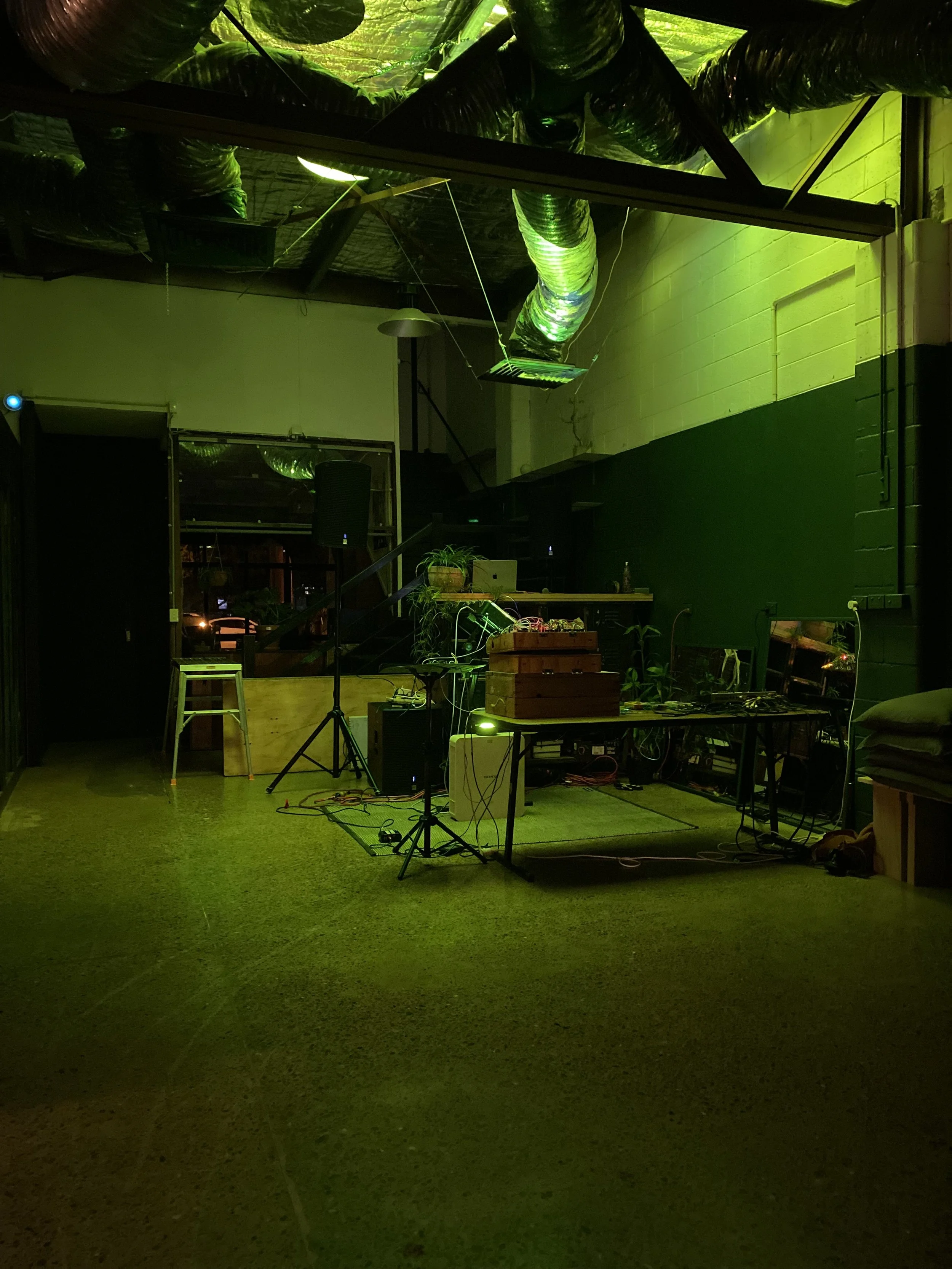 In the foreground a women is in conversation about making ceramics across a table, which is full of potters tools and some cups in their initial stages.  in the background are four women talking and laughing. 