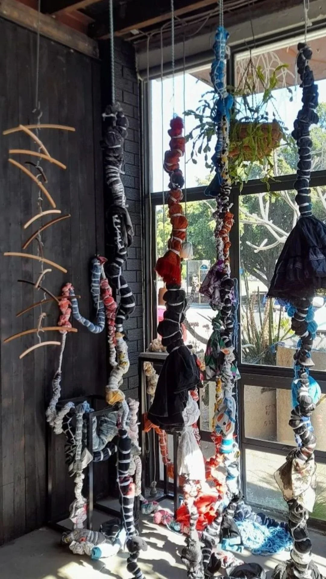 Art installation of bound colorful fabric in thick twisted rope, hanging from the ceiling of Lab 266