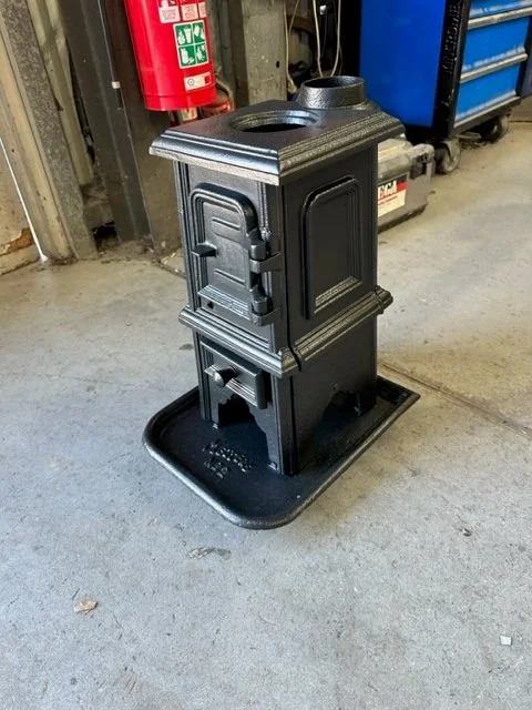 A black cast iron stove restoration powder coating