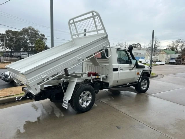 White ute truck with an elevated tipper cargo bed, custom ute tray and powder coating Wagga Wagga. Sandblasting and powder coating service Wagga with custom truck and ute bodies and ute trays.  Custom tipper truck bed.