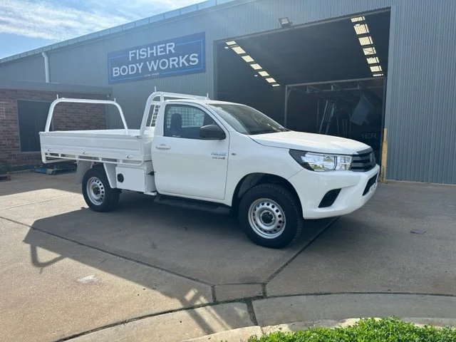 White ute parked outside Fisher Body Works building, custom ute tray and powder coating Wagga Wagga. Sandblasting and powder coating service Wagga with custom truck and ute bodies and ute trays. 