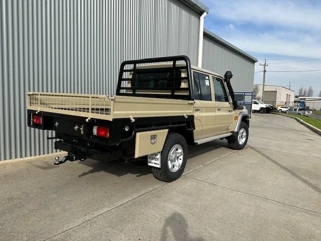 Beige utility pickup truck with a flatbed and black metal safety bars, custom fabricated ute tray flatbed. Powder coated and sandblasted, and installed. Custom designed and welded ute tray.